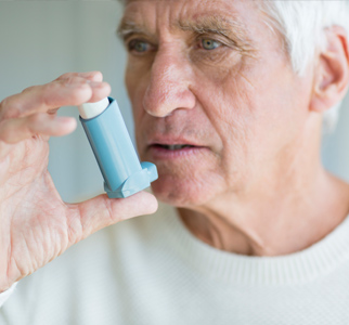 Older man preparing to use an inhaler